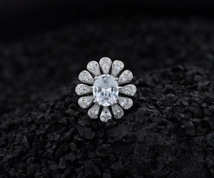 Vista macro di un anello in argento S925 con diamante ovale su roccia scura