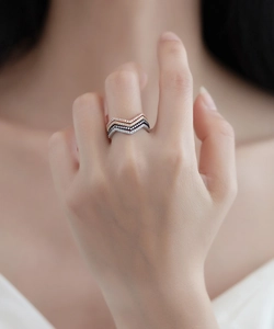 Detail of four-color stacked V-shaped rings with pave-set micro diamonds on model