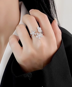 Close-up of sterling silver adjustable ring featuring zircon floral and butterfly details