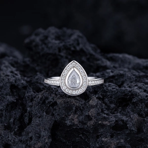 Sparkling S925 sterling silver pear-cut halo ring on dark volcanic rock background