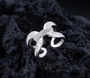 Dettaglio macro di anello in argento S925 con cristalli pavé su sfondo di pietra scura