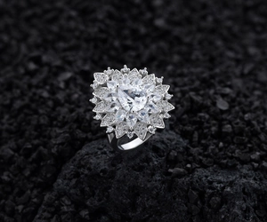 Macro detail of pear-shaped floral silver ring with multi-layer brilliant cluster setting