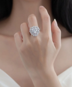 Macro detail of luxury heart-shaped diamond ring with double halo setting on finger