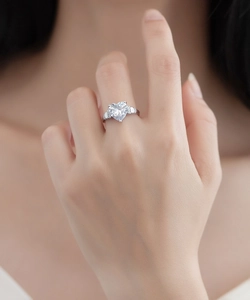 Gros plan d'une bague en argent s925 avec diamant en forme de cœur et pierres de côté