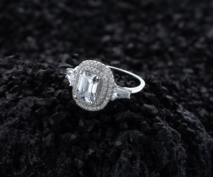 Detailed macro view of S925 silver emerald cut ring with micro-pave halo and trapezoid diamonds
