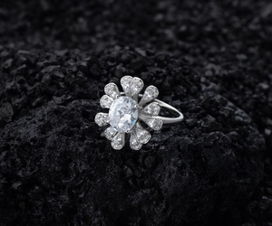 Primo piano dettagliato di un anello a forma di fiore con una grande gemma ovale in argento