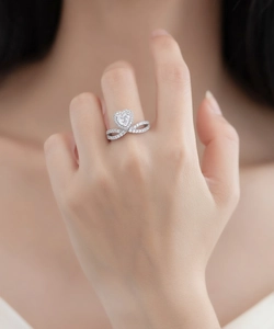 Gros plan sur une bague diamant en forme de cœur avec un anneau infini en argent fin