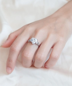 Gros plan d'une bague en argent S925 avec diamant en forme de cœur portée au doigt