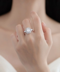 Macro view of emerald cut gemstone ring with double halo pavé setting on model finger