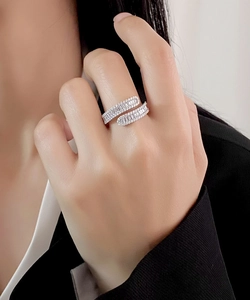 Detailed close-up of a silver crossover ring with pavé-set rectangular cubic zirconia