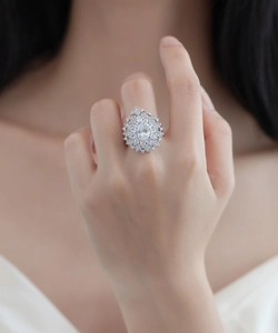 Macro detail of pear-shaped floral ring featuring layered sparkling diamond petals