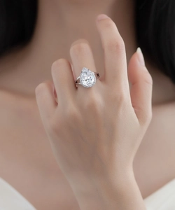 On-finger view of a S925 silver ring featuring a pear-shaped cubic zirconia halo stone