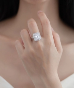 Macro shot of an elegant emerald-cut silver ring with a halo of pavé-set diamonds