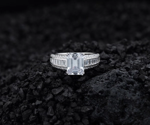 Vue macro d'une bague en argent sertie d'un diamant taille émeraude sur fond de pierre