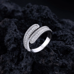 Crossed S925 silver ring with baguette and round cubic zirconia on black volcanic rock
