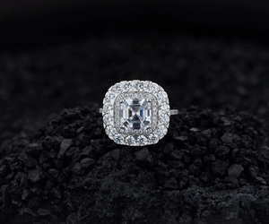 Gros plan d'une bague en argent avec diamant taille émeraude et double halo scintillant