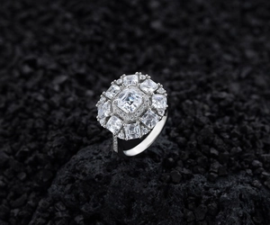 Macro shot of a luxury S925 sterling silver square diamond ring on black stones