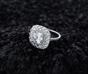 Vue latérale macro de la bague double halo en argent sur fond de roche volcanique