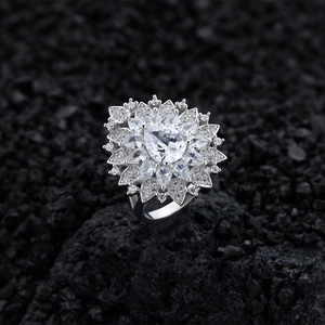 Pear-shaped floral halo ring in silver with full diamond cluster on black volcanic rock