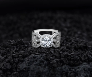 Macro view of a wide silver leaf ring with square center stone and hollow carving