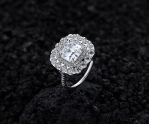 Gros plan d'une bague de luxe en argent sterling avec halo carré et pierre centrale