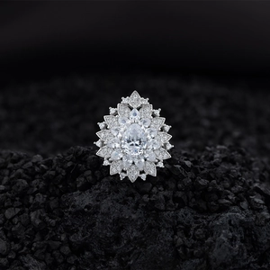 Elegant pear-shaped floral diamond cluster ring in sterling silver on dark charcoal