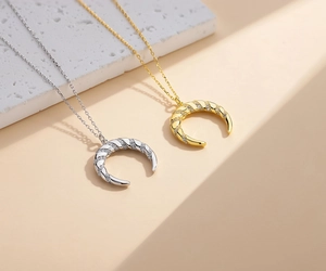 Détail de pendentifs en croissant de lune avec texture spirale et zircons pavés