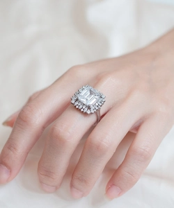 Macro detail of emerald-cut sparkling silver ring with flower halo cluster setting