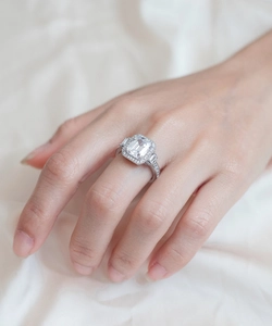 Detail of 925 sterling silver ring featuring an emerald cut central gem and halo setting