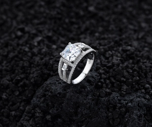 Macro-opname van 925 zilveren ring met prinses geslepen zirkonia op zwarte vulkanische rots