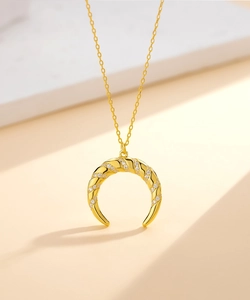Vue macro d'un pendentif lune plaqué or 14k avec texture torsadée et zircons incrustés