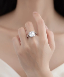 Close-up of S925 sterling silver halo ring with emerald cut diamond and split shank band