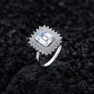 Elegant rectangle emerald cut diamond ring with double halo pavé on black volcanic rock