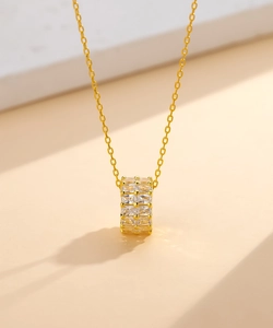 Vue macro du pendentif cylindre en argent 925 plaqué or 14k avec des pierres zircon