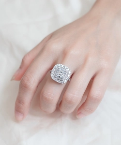 Gros plan d'une bague de luxe en argent avec double halo de diamants portée à la main