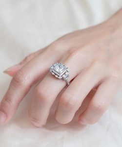 Vue détaillée d'une bague diamant carrée avec double halo et accents de baguettes
