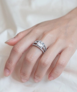 Detail van een ring met vierkante diamant en een luxe drievoudige band met pavé-zetting