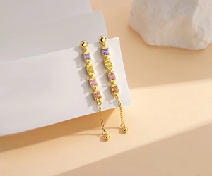 Detailed macro view of long tassel earrings with four colorful square-cut gemstones