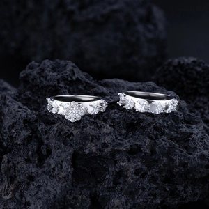 Close-up of S925 silver rings with marquise stones on black volcanic rock background