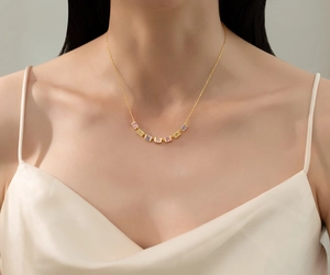 Close-up of S925 silver necklace featuring seven colorful square-cut gemstones on a gold chain