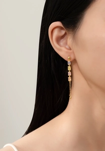 Detailed close-up of long tassel earrings with square colorful gemstones and gold beads