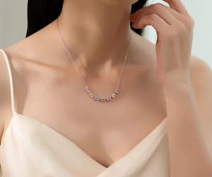 Macro detail of S925 sterling silver necklace with a curved row of colorful square gems