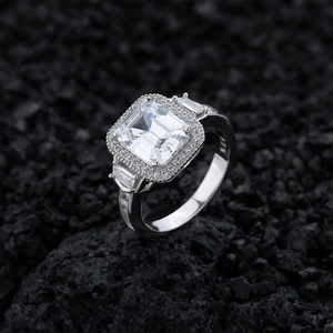 925 silver halo ring with emerald-cut zirconia and side baguette stones on volcanic rock