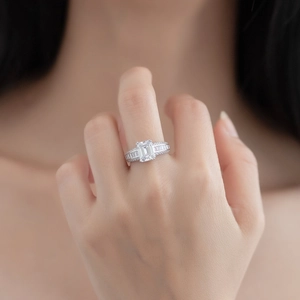 Élégante bague en argent à coupe émeraude avec pierres baguette sur le doigt