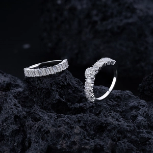 Macro shot of silver sterling nesting rings with radiant diamonds on black volcanic rock