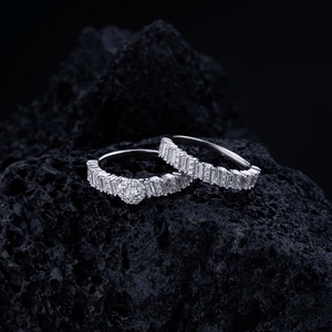 Macro shot of silver stackable rings with baguette diamonds on dark volcanic rock