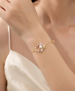 Detail eines 18K Goldarmbands mit Blumenkranz, Perlen und bunten Zirkon-Edelsteinen