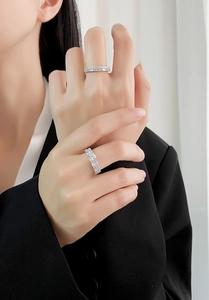 Close-up of luxury 925 silver rings with round and baguette cut zircons on a model's hand