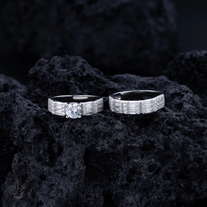 Detailed view of sterling silver rings with emerald cut diamonds on black volcanic rock