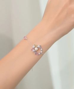 Details des Silber-Schmucksets mit buntem Edelstein-Blumen-Design und Perle am Handgelenk